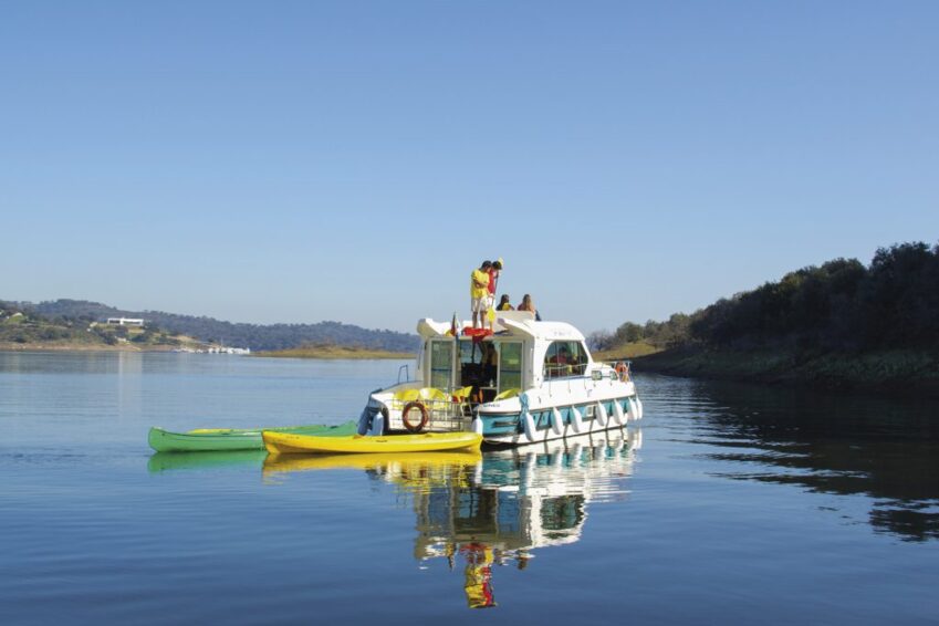 Grande lago de Portugal | Danfluvial Barco fluvial de alquiler con un kayak amarrado navegando por el Grande Lago de Portugal