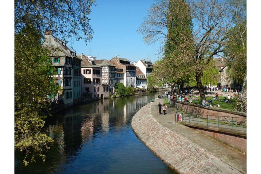 River tourism France in Alsace-Lorraine | Danfluvial Canal fluvial rodeado de casas tradicionales alsacianas con fachadas entramadas de madera en Francia.