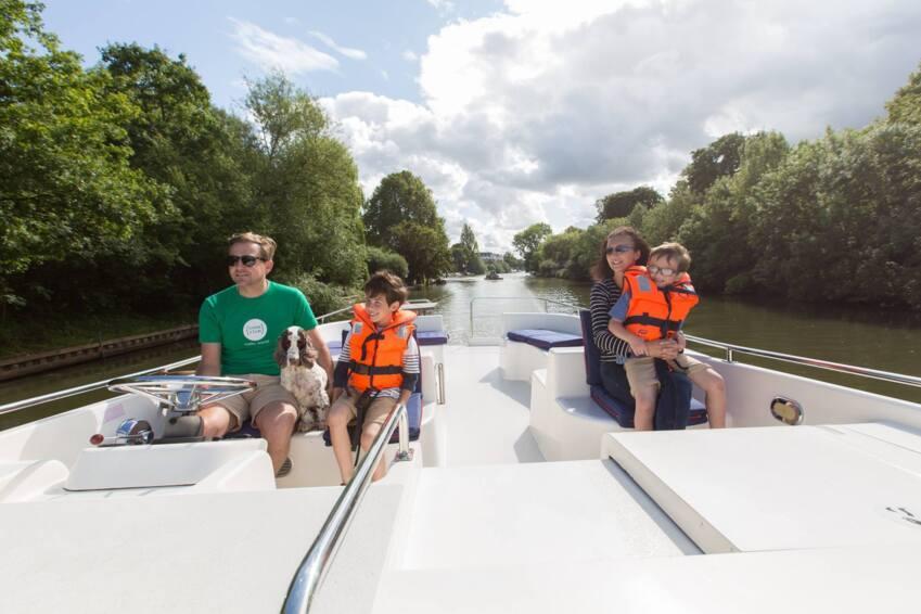 Barcos fluviales | Danfluvial Niños con chalecos salvavidas en la proa de un barco fluvial durante un viaje familiar por Inglaterra.