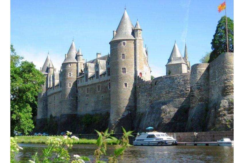River tourism France in Brittany | Danfluvial Un barco fluvial navegando frente a las imponentes torres fortificadas del castillo medieval de Carcasona en Francia.