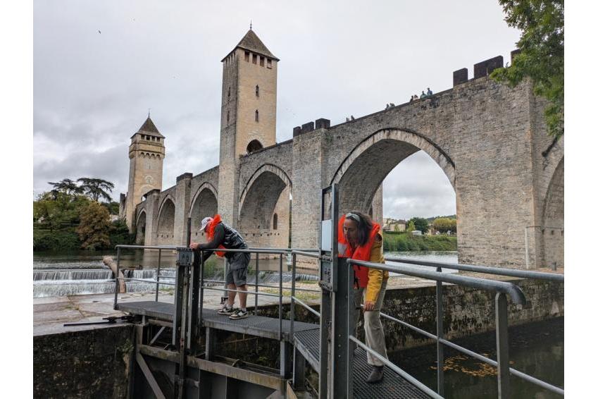 What to bring on a river cruise Barco de recreo cruzando un puente medieval fortificado durante un crucero fluvial con Danfluvial.