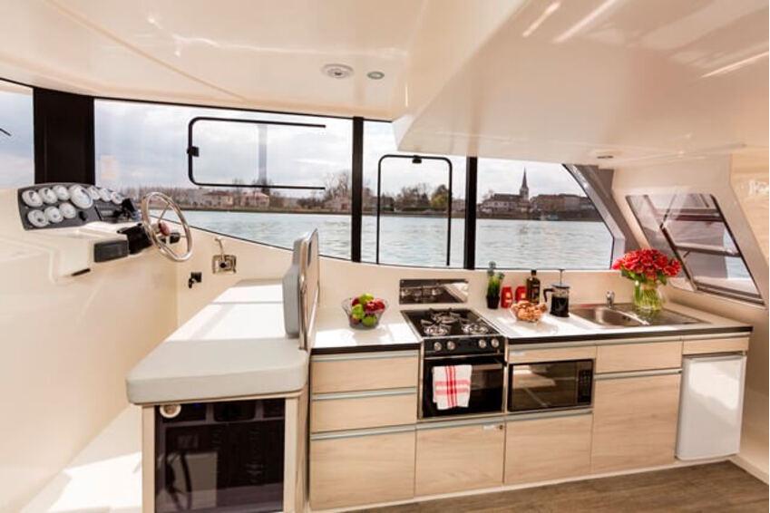 Interior de barco fluvial | Danfluvial Cocina totalmente equipada y zona de salón interior de un barco fluvial.