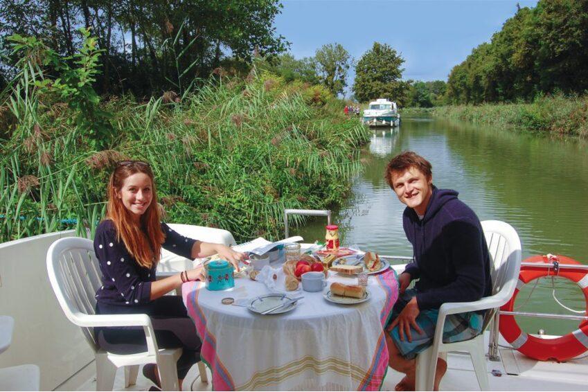 food on river cruise Pareja disfrutando de una comida al aire libre en la terraza de un crucero fluvial con Danfluvial.